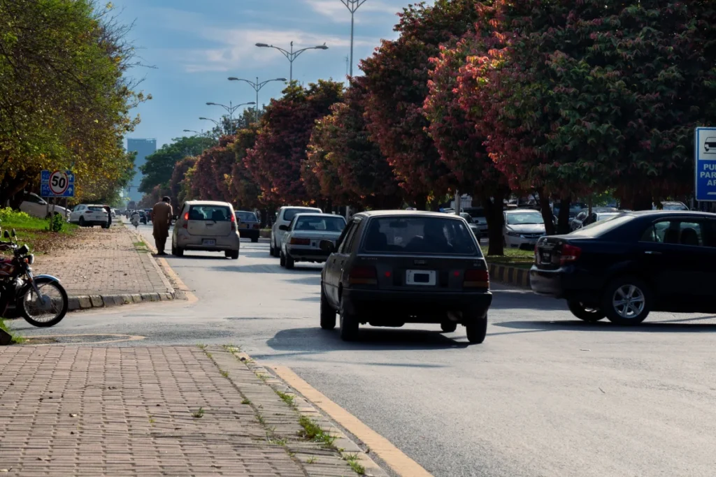 Cars on a tree-lined road in Islamabad, Pakistan.