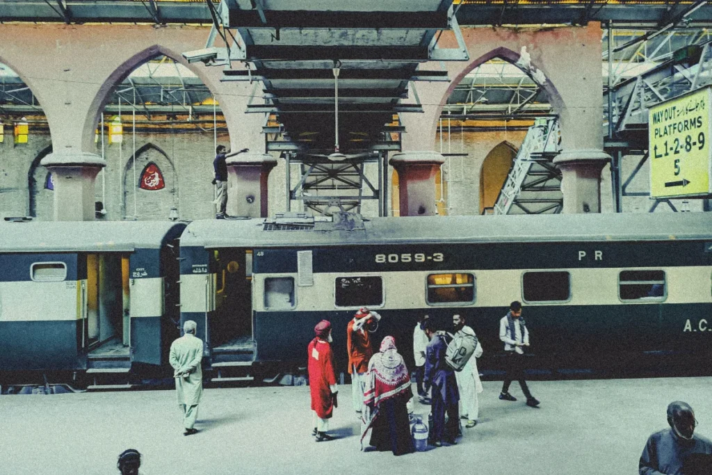 Passengers beside a train on a platform at Lahore Railway Station, Pakistan.