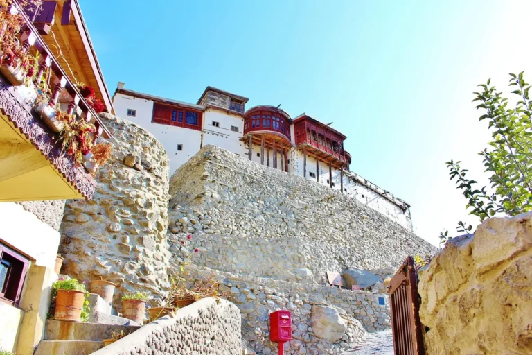 Baltit Fort's white walls and carved timber balconies rising above stone terraces in Karimabad, Hunza.