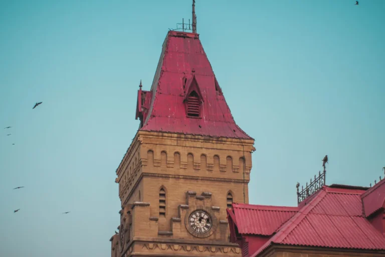 Sandstone clock tower with a red pitched roof at Empress Market, a colonial-era landmark in central Karachi