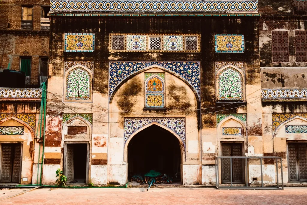 The tile-mosaic facade and arched gateway of a historic building in the old city of Lahore, Pakistan.
