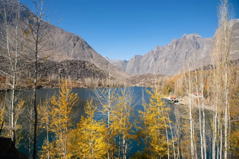 Lower Kachura Lake framed by golden autumn trees and rugged mountains near Skardu, Pakistan.